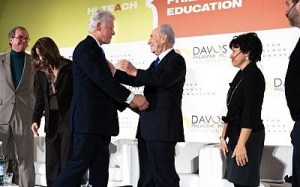 President Shimon Peres shakes hands with former US President Bill Clinton, during a meeting at the World Economic Forum in Davos, Switzerland, in 2010 (Photo credit: Sergei Illin/Flash 90)