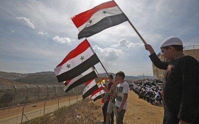 Young members of the Druze community wave Syrian flags during a rally in the Druze village of Majdal Shams in the Golan Heights on October 6, 2018, commemorating the 45th anniversary of the 1973 Arab-Israeli war (AFP Photo/Jalaa Marey)