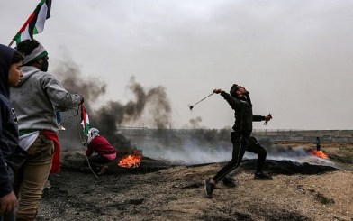 A Palestinian protester uses a slingshot to hurl a rock toward Israeli forces during clashes following a demonstration along the border with Israel in Malaka east of Gaza City on March 30, 2019 (Mahmud Hams/AFP)