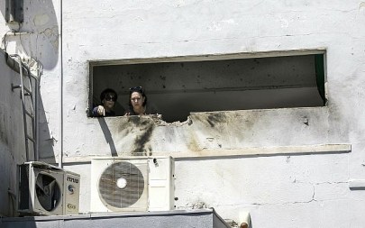 Women look at the damage caused by a rocket fired from Gaza that hit a house in a town in Israel near the border with Gaza, Saturday, May 4, 2019. (AP/Tsafrir Abayov)