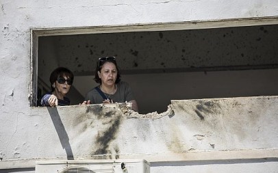 Women look at the damage caused by a rocket fired from Gaza that hit a house in southern Israel near the border with Gaza, Saturday, May 4, 2019 (AP Photo/Tsafrir Abayov)