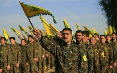 Hezbollah fighters hold flags, as they attend the memorial of slain leader Sheik Abbas al-Mousawi, killed by an Israeli airstrike in 1992, in Tefahta village, south Lebanon, February 13, 2016. (Mohammed Zaatari/AP)