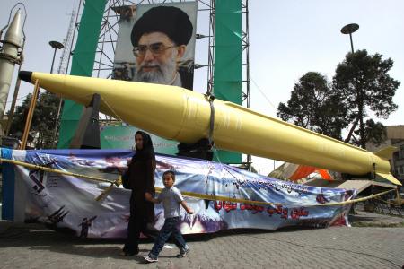  A woman and boy walk past Shahab-2 (L) and Shahab-3 missiles on display in Tehran in 2008 (file)
