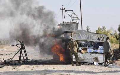 Illustrative: Popular Mobilization Forces members stand by a burning truck after a drone attack blamed on Israel near Qaim border crossing, in Anbar province, Iraq, August 25, 2019. (AP Photo)