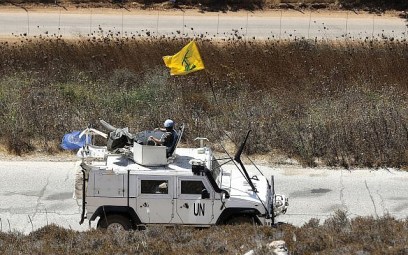 Spanish UN peacekeepers patrolling along the Lebanese-Israeli border pass a Hezbollah flag, in the southern Lebanese village of Kfar Kila, Lebanon, Monday, Sept. 2, 2019. (AP Photo/Hussein Malla)