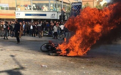 Iranian protesters gather around a burning motorcycle during a demonstration against an increase in gasoline prices in the central city of Isfahan, on November 16, 2019. (AFP)