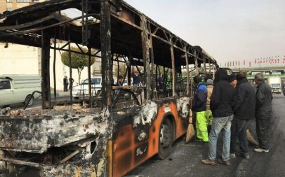 Iranians inspect the wreckage of a bus that was set ablaze by protesters during a demonstration against a rise in gasoline prices in the central city of Isfahan on November 17, 2019. (AFP)