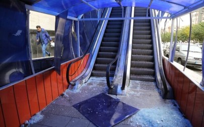 An Iranian man walks past a the entrance of a pedestrian overpass that was vandalized by protesters in Tehran on November 19, 2019. (ATTA KENARE/AFP)