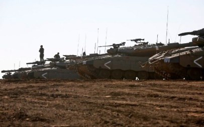 An Israeli soldier stands on a Merkava tank deployed on the Golan Heights on November 20, 2019. (JALAA MAREY / AFP)