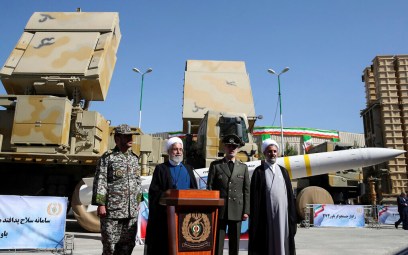 President Hassan Rouhani, second left, speaks during a ceremony to unveil the Iran-made Bavar-373, a long-range surface-to-air missile system, displayed at rear, as his Defense Minister Gen. Amir Hatami, second right, commander of army's air defense force Gen. Alireza Sabahifard, left, and the chairman of the parliament's National Security and Foreign Policy Committee Mojtaba Zolnour, listen, at an undisclosed location in Iran,, August 22, 2019. (Iranian Presidency Office via AP)