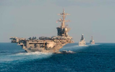 In this photo from the US Navy provided on November 19, 2019, the aircraft carrier USS Abraham Lincoln, left, the air-defense destroyer HMS Defender and the guided-missile destroyer USS Farragut transit the Strait of Hormuz with the guided-missile cruiser USS Leyte Gulf. (Mass Communication Specialist 3rd Class Zachary Pearson/U.S. Navy via AP)