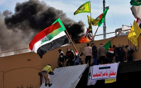 Pro-Iranian militiamen and their supporters set a fire during a sit-in in front of the US embassy in Baghdad, Iraq, January 1, 2020. (AP Photo/Khalid Mohammed)