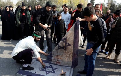 Protesters burn representations of Israeli flag during a demonstration over the US airstrike in Iraq that killed Iranian Revolutionary Guard Gen. Qassem Soleimani, in Tehran, Iran, Jan. 3, 2020 (AP Photo/Vahid Salemi)