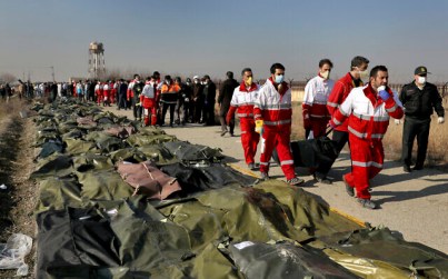 Rescue workers carry the body of a victim of a Ukrainian plane crash in Shahedshahr, southwest of Tehran, Iran, January 8, 2020 (AP/Ebrahim Noroozi)