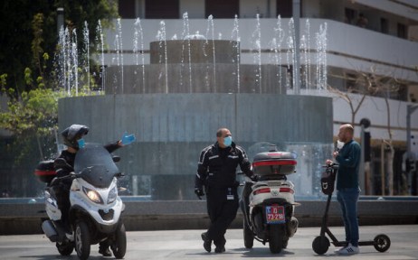 Israeli police  patrol in Dizengoff square in Tel Aviv to check people are not disobeying the government's orders on a partial lockdown in order to prevent the spread of the coronavirus, April 14, 2020. (Miriam Alster/Flash90)