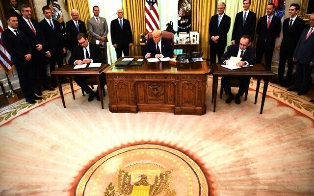 US President Donald Trump signs a document as Kosovar Prime Minister Avdullah Hoti (R) and Serbian President Aleksandar Vucic (L)  sign an agreement on opening economic relations, in the Oval Office of the White House in Washington, DC, on September 4, 2020. (Photo by Brendan Smialowski / AFP)