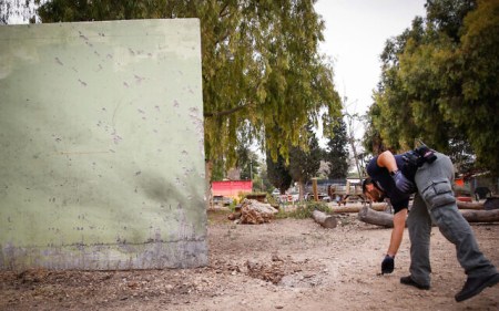 A police sapper inspects the scene where a rocket fired from the Gaza Strip fell near houses on a kibbutz in southern Israel on April 24, 2021 (Flash90)