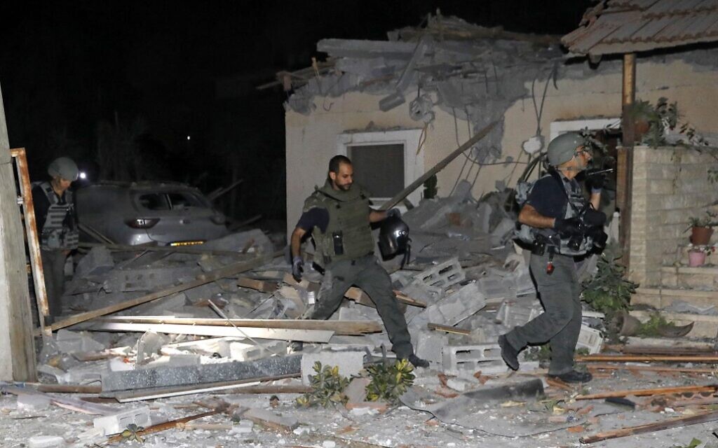 Israeli firefighters and security forces inspect damage to a house hit by a rocket fired from Gaza on May 12, 2021 ( GIL COHEN-MAGEN / AFP)