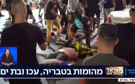 A man beats someone lying prone on the ground in the Israeli city of Bat Yam amid interethnic violence across Israel, May 12, 2021. (Screenshot)