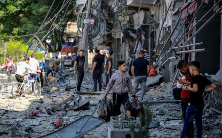 Palestinians check the damage caused after a 15-floor building was destroyed in an Israeli airstrike in Gaza City, May 13, 2021. (Atia Mohammed/Flash90)