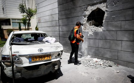A man inspects damage caused to a building in the southern coastal city of Ashkelon, after it was hit by a rocket fired by Palestinian terrorists in the Gaza Strip, May 14, 2021. (Yonatan Sindel/Flash90)